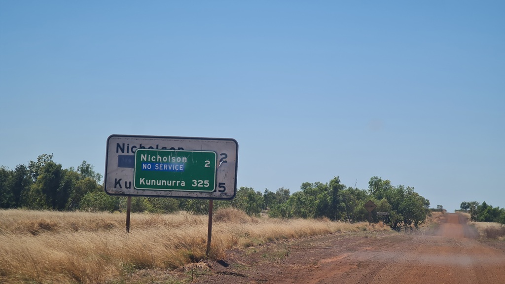 A distance sign on Duncan Road. Photo shows the Road going into the distance and the road conditions.