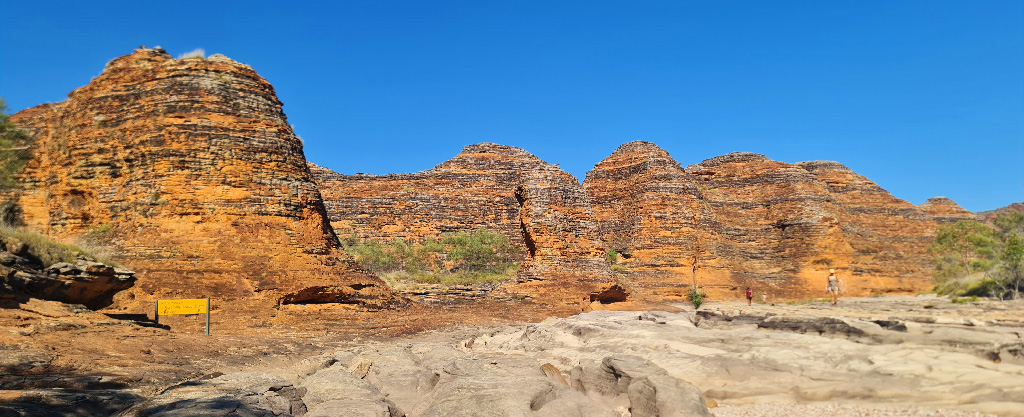 The Ultimate Kimberley Travel Guide: Off-Grid Planning for Small Caravans & Hybrids Landscape view of the Purnululu beehive domes with park signage, highlighting the rugged terrain and blue sky of the Kimberley dry season.