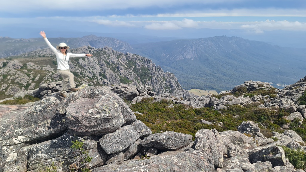 Muay showing off the expansive 360-degree views of the Kentish plains and Bass Strait from the summit of Mt Roland, Sheffield, Tasmania.