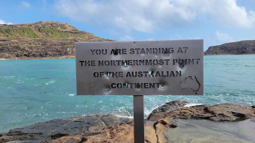 The iconic 'You are standing at the northernmost point of the Australian Continent' sign at Pajinka, Cape York, with the Torres Strait in the background.