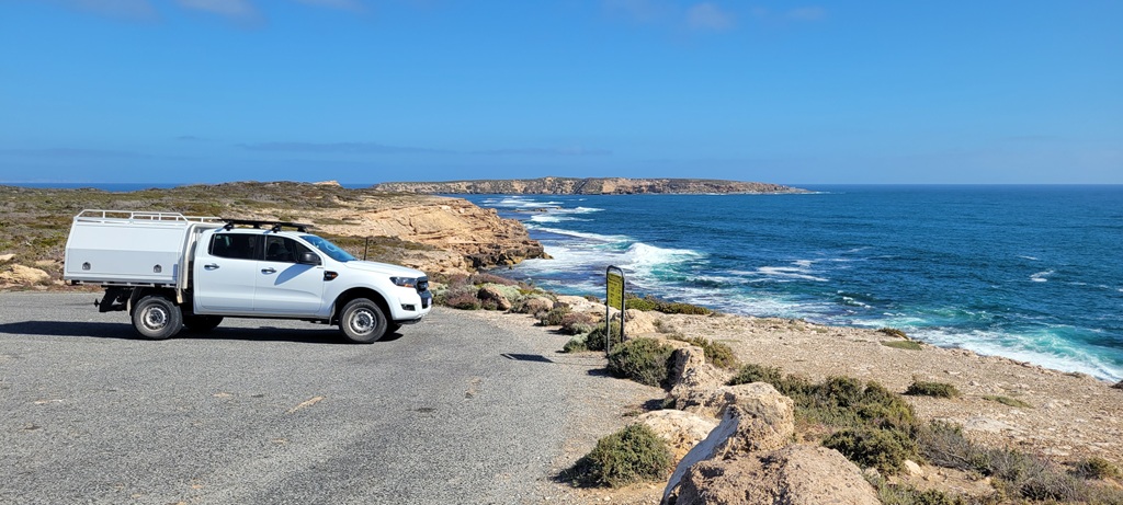 A breathtaking view from a coastal lookout on the Eyre Peninsula during a South Australia road trip, showing rugged limestone cliffs, crashing waves of the Southern Ocean