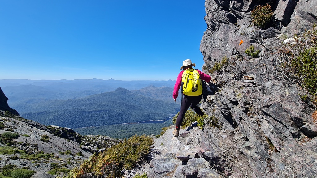 Hiking the rugged Mt Murchison track in West Coast Tasmania. The photo shows the steep, rocky terrain and panoramic wilderness views that experienced hikers can expect on this challenging trail.