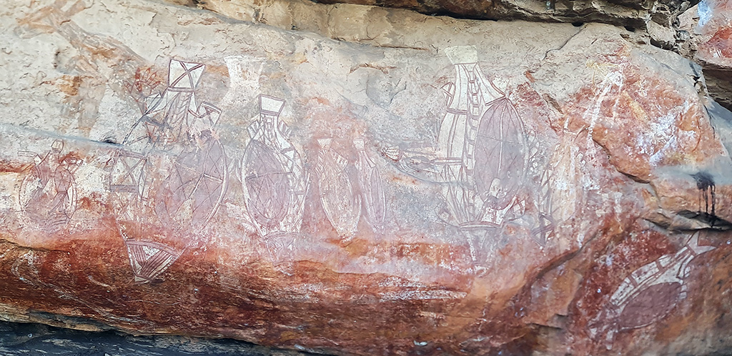 Ancient Aboriginal rock art in the x-ray style showing fish and internal structures, painted on a sandstone overhang in Kakadu National Park.