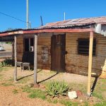 Cooper’s Cottage in Lightning Ridge, a historic 1916 opal miner's hut built from rusted corrugated iron and local timber, featuring a 
