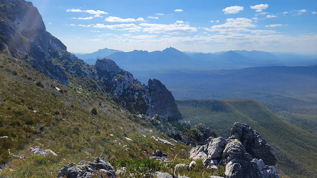 Rugged alpine ridge track and rocky spires on the way up to the summit of The Needles, looking out over the Southwest National Park wilderness in Tasmania.
