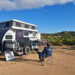 Off-road hybrid caravan setup at a remote campsite demonstrating site positioning and caravan security in the Australian bush.