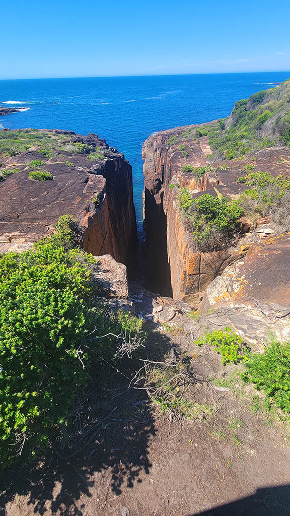 Looking down into the narrow rock fissure at Slot Canyon Lookout near One Mile Beach