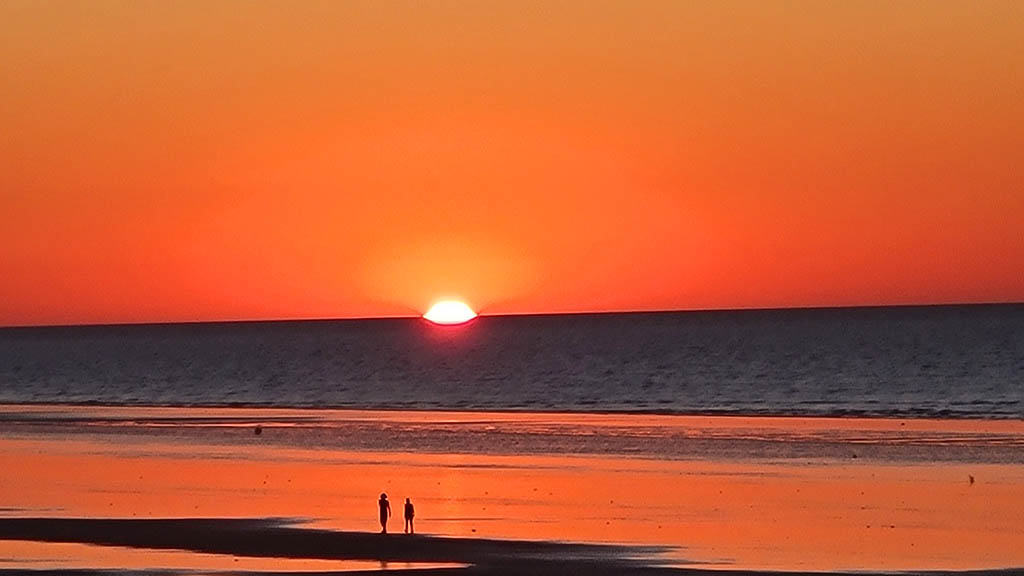 Silhouette of people walking on the tidal flats during sunset at Eighty Mile Beach, Western Australia